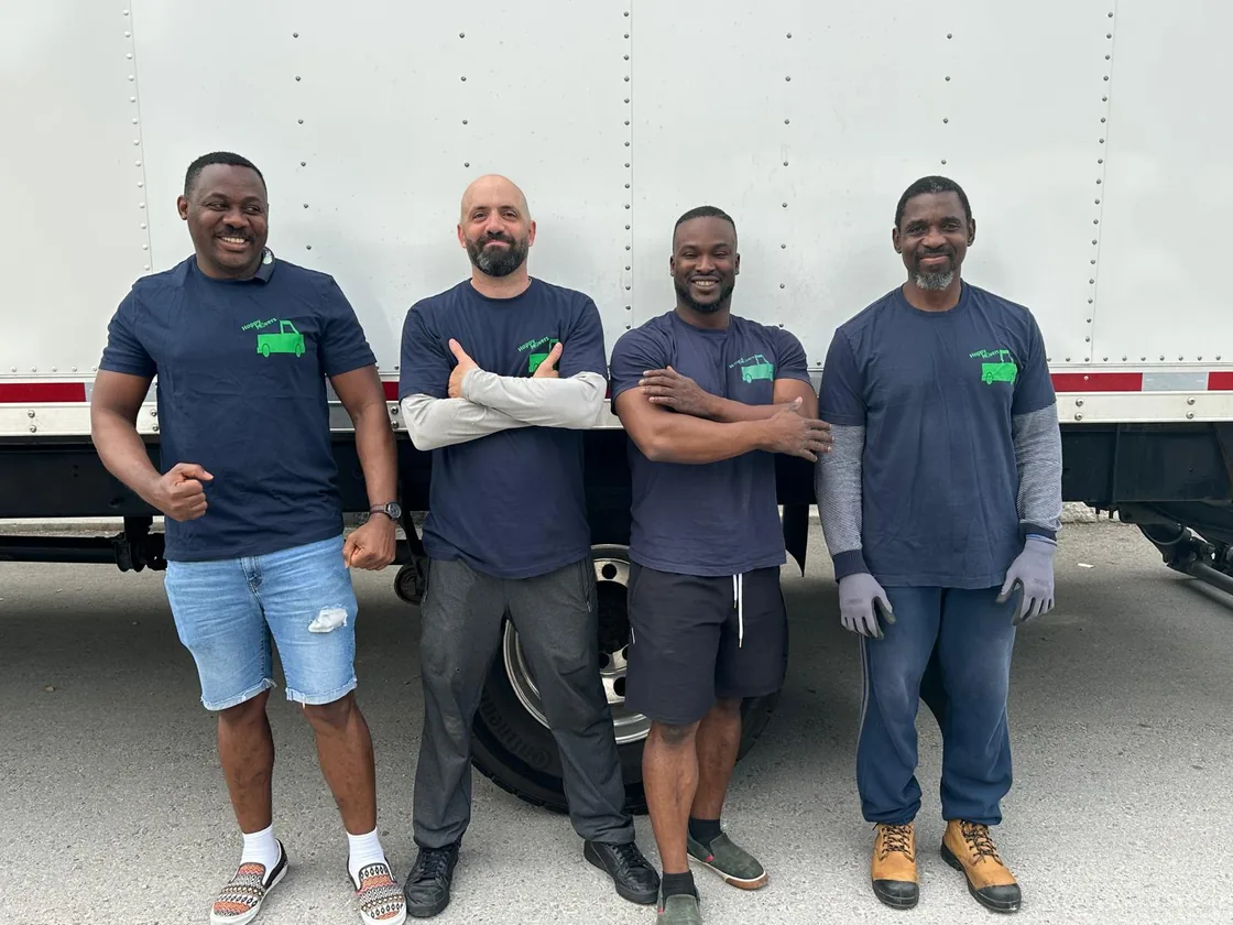 The Happy Movers crew standing together in front of their moving truck