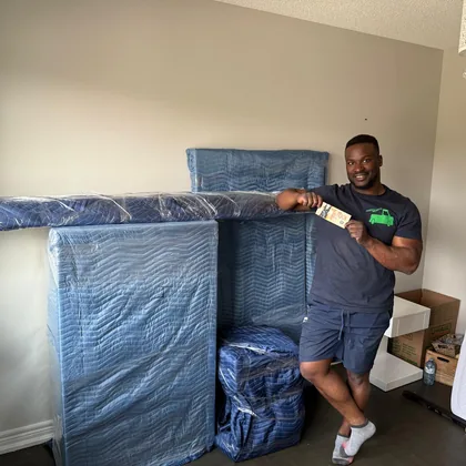 Mover wrapping a piece of furniture in protective blankets