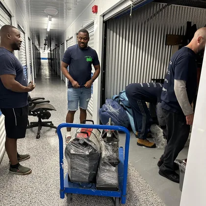 Happy Movers crew at a storage unit loading belongings between homes