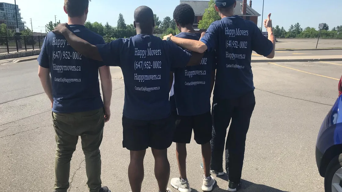 Happy Movers team in branded shirts beside their truck before a move