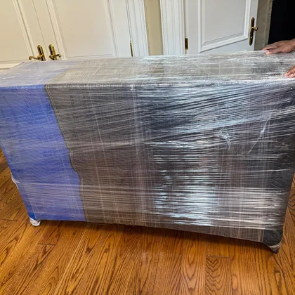 Wrapped dining table on a dolly on a hardwood floor